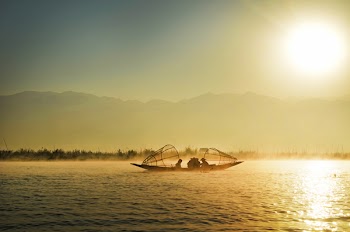 Group of People Riding Boat in the Middle of Water during Sunrise