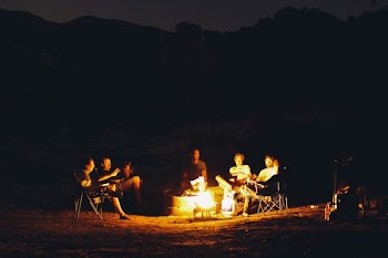 group of people seating around bonfire