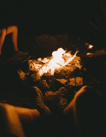 Group of People Sitting Beside the Bonfire during Night Time