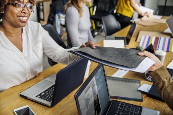 Group of People Sitting Down Near Brown Wooden With Assorted Laptop Computers