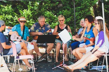 Group of People Sitting Down Playing Music Instruments