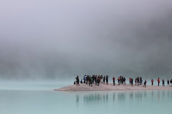 group of people standing on brown stand surrounded by body of water