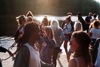group of people standing on dock beside body of water