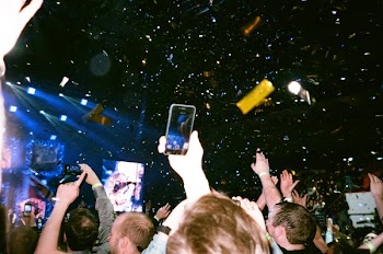 Group of People Standing Taking a Picture on a Woman on Stage Performing
