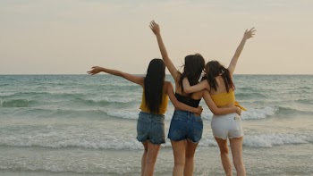 Group of three asian young women walking on beach Free Photo