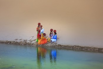 Group of Women Sitting Near Body of Water