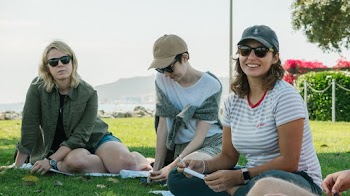 Group Of Women Sitting On Grass 