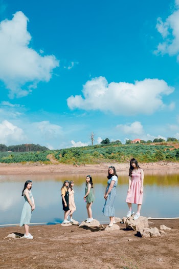 Group Of Women Standing Besides Body Of Water