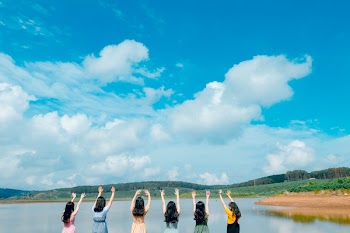 Group of Women Wearing Dress Raising Up Their Hands on Air Under Cloudy Sky