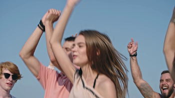 Group of young exhilarated people jumping together with raised ...