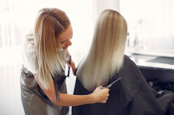 Hairdresser cut hair her client in a hair salon Free Photo