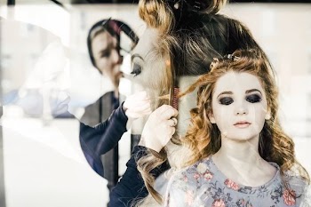 hairdresser dressing woman's hair inside room