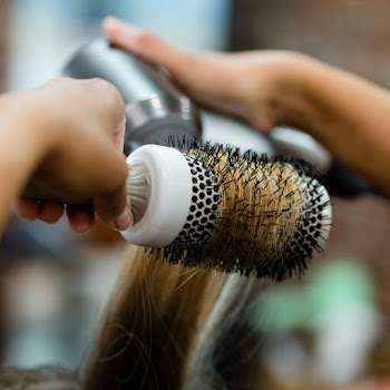 Hairstylist blow drying a customer's hair  | Free stock photo | High Resolution image