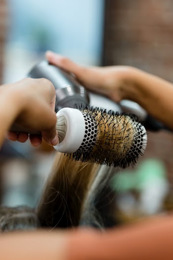 Hairstylist blow drying the customer's hair | Free stock photo | High Resolution image