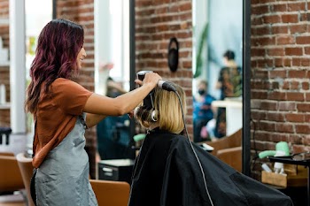 Hairstylist curling the customer's hair at a… | Free stock photo | High Resolution image