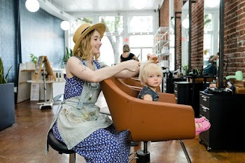 Hairstylist giving a haircut to an adorable… | Free stock photo | High Resolution image
