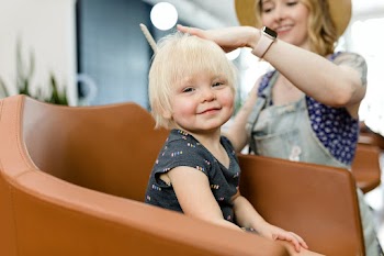 Hairstylist giving a haircut to an adorable… | Free stock photo | High Resolution image