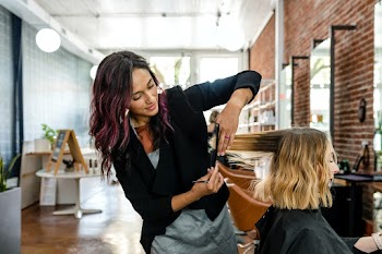 Hairstylist trimming hair of the customer in… | Free stock photo | High Resolution image