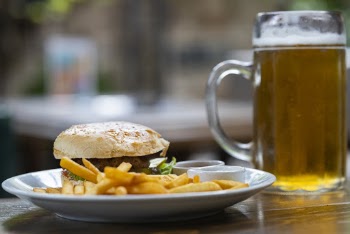 Hamburger and Fries Beside Mug With Beer