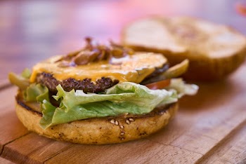 Hamburger With Top Bun Taken Off on Wooden Table