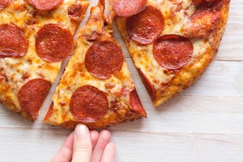 Hand Grabbing A Hot Slice Of Pizza