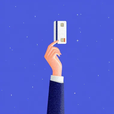 Hand Holding a Credit Card Against a Blue Background Hand Holding a Credit Card Against a Blue Background