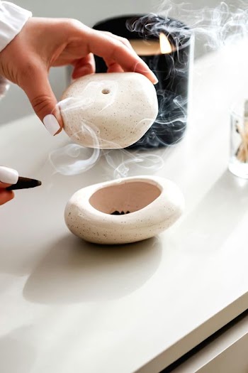 Hand Holding a Modern Incense Burner with Aromatic Smoke