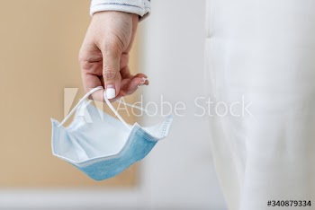 Hand holding a used face mask during coronavirus pandemic