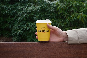 Hand Holding Coffee Cup PSD Mockup iginal quality brandname coffee - taste 