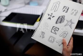 Hand Holding Notebook With Drew Brand Logo Creative Design Ideas
