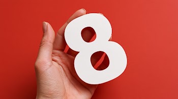 Hand Holding Number 8 on Red Background