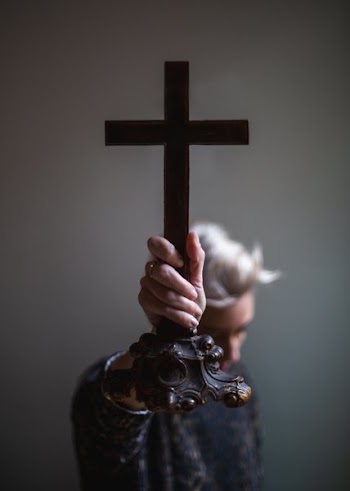 Hand Holding Out Antique Cross