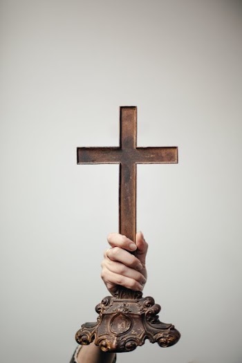 Hand Holds Up Antique Cross