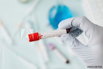Hand of doctor holding a blood test tube during covid-19 outbreak