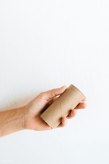 Hand with an empty tissue paper roll on a white background | Free  photo - 2315466