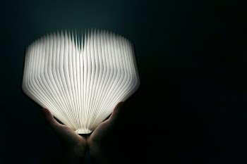 Hands Holding Glowing Book