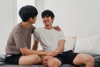 Handsome asian gay couple talking on bed at home. young asian lgbtq+ guy happy relax rest together spend romantic time after wake up in bedroom at modern house in the morning . Free Photo