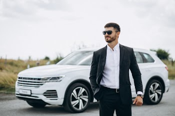 Handsome business man by the white car Free Photo