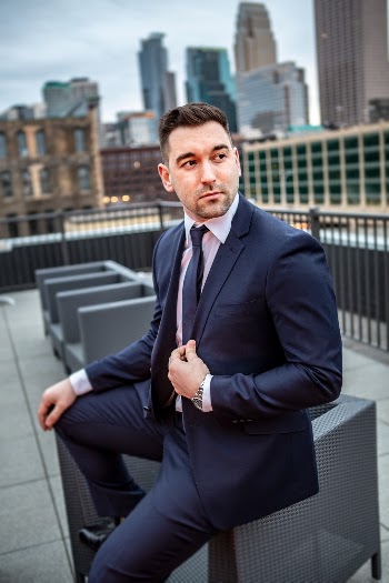 handsome man in suit on rooftop in front of skyline