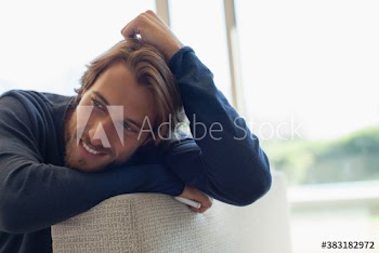 Handsome young man leaning on sofa