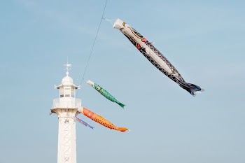 hanging koi fish banners near lighthouse
