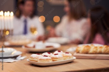 Hanukkah dinner. Family gathered around the table with traditional dishes
