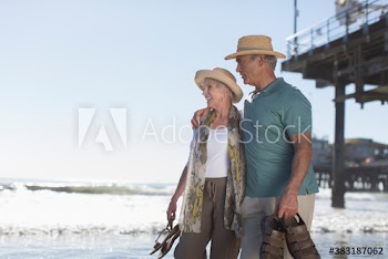 Happy active senior couple on sunny ocean beach