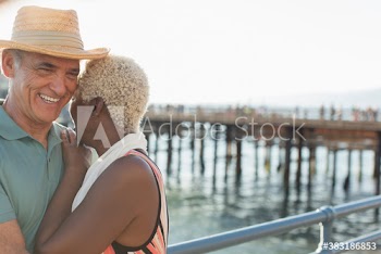 Happy active senior couple on sunny ocean pier