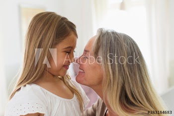 Happy affectionate grandmother and granddaughter face to face