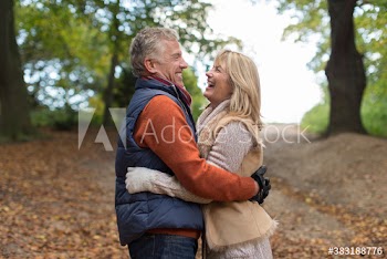 Happy affectionate mature couple hugging in autumn park