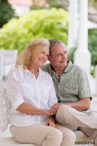 Happy affectionate senior couple hugging on patio