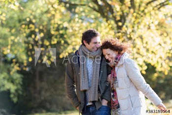 Happy affectionate young couple walking in autumn park