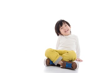 Happy asian boy sitting on white background isolated
