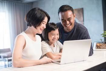 Happy Asian family looking at the computer together at home.